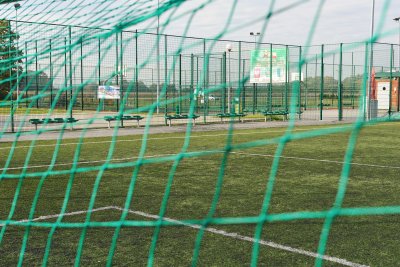 na zdjęciu widok zza bramki na boisko ze sztucznej trawy